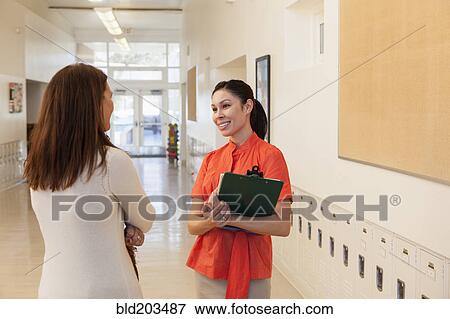 Stock Photo - Teachers talking in school hallway. Fotosearch