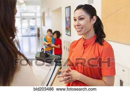 Stock Photograph - Teachers talking in school hallway. Fotosearch