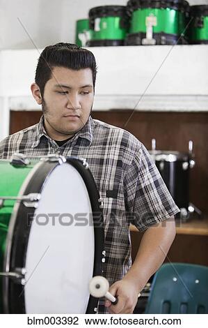 Stock Image - Teenage boy playing drum. Fotosearch