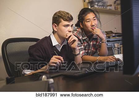 Stock Image - Teenage boys using computer. Fotosearch