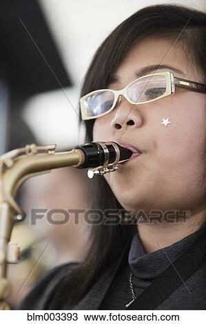 Teenage girl playing saxophone View Large Photo Image Stock Image - Teenage girl playing saxophone. Fotosearch
