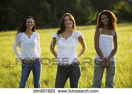 Three women standing in meadow View Large Photo Image Stock Photography - Three women standing in meadow . Fotosearch