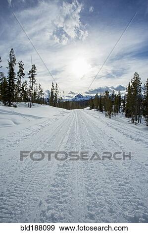 Stock Photo - Tire tracks on snowy remote road. Fotosearch