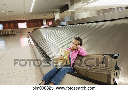 Tired Asian girl sitting on luggage carousel View Large Photo Image Stock Photography - Tired Asian girl sitting on luggage carousel. Fotosearch
