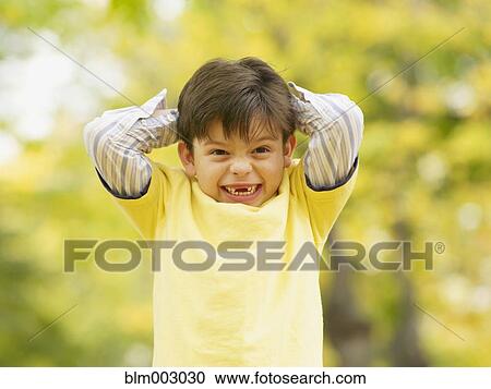 Stock Image - Toothless Hispanic boy smiling outdoors in autumn. Fotosearch