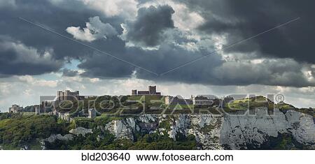 Stock Image - Town built on white cliffs under stormy sky, Dover, Kent, England. Fotosearch