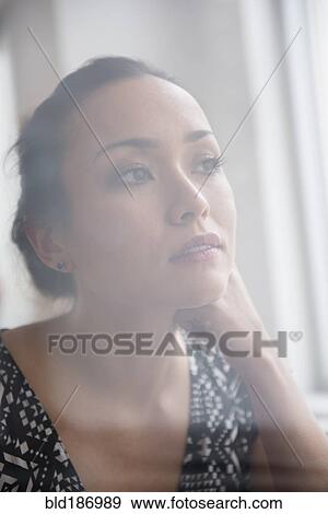 Tranquil woman looking out window View Large Photo Image Stock Photo - Tranquil woman looking out window. Fotosearch