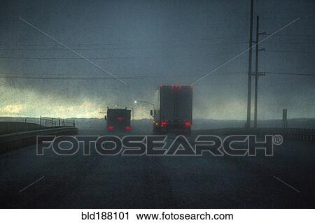 Trucks driving on stormy rural road View Large Photo Image Stock Image - Trucks driving on stormy rural road. Fotosearch
