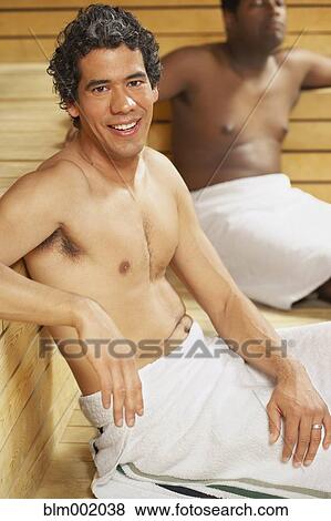 Stock Photo - Two multi-ethnic men relaxing in sauna. Fotosearch