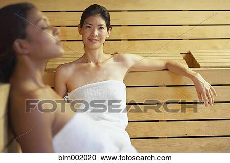 Two multi-ethnic women relaxing in sauna View Large Photo Image Stock Image - Two multi-ethnic women relaxing in sauna. Fotosearch