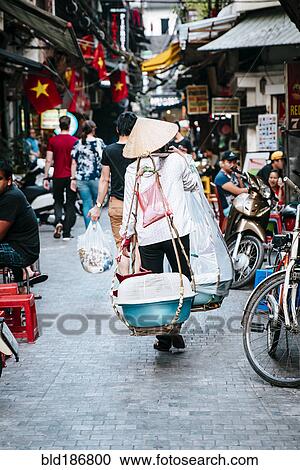 Stock Image - Vendor walking on urban street. Fotosearch