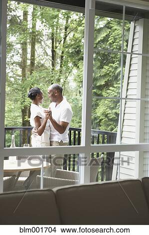 Picture - View through window to couple dancing on deck. Fotosearch
