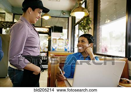 Picture - Waitress taking businesswoman's order in restaurant. Fotosearch