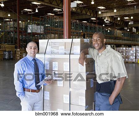 Stock Photo - Warehouse worker and boss next to pallet of boxes. Fotosearch