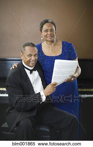 Well dressed African couple with sheet music in front of piano View Large Photo Image Stock Photography - Well dressed African couple with sheet music in front of piano. Fotosearch