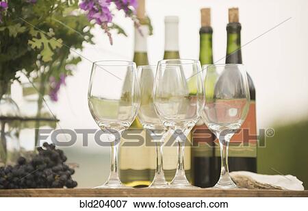 Wine bottle, grapes and glasses on table outdoors View Large Photo Image Stock Photo - Wine bottle, grapes and glasses on table outdoors. Fotosearch