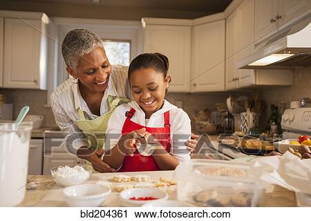 Woman and granddaughter baking in kitchen View Large Photo Image Stock Image - Woman and granddaughter baking in kitchen. Fotosearch