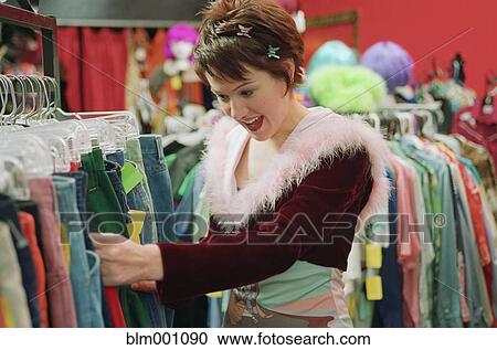 Stock Image - Woman buying clothing at second hand shop. Fotosearch