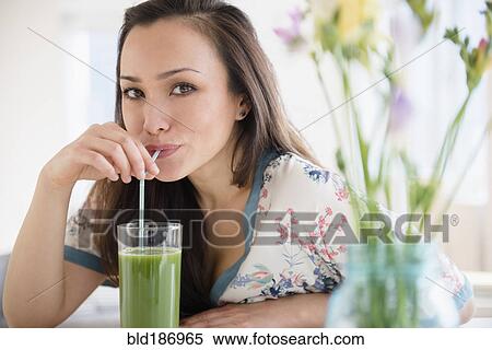 Woman drinking green juice View Large Photo Image Stock Photography - Woman drinking green juice. Fotosearch