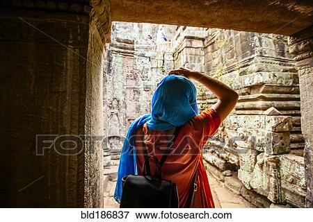 Stock Photo - Woman exploring ruins at Angkor Wat, Siem Reap, Cambodia. Fotosearch