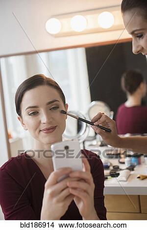 Woman having makeup applied by stylist View Large Photo Image Picture - Woman having makeup applied by stylist. Fotosearch