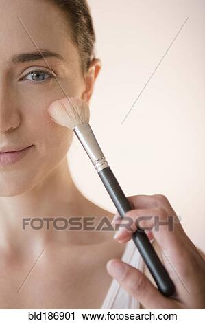 Stock Image - Woman having makeup applied by stylist. Fotosearch