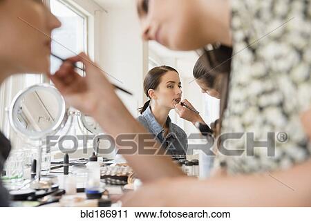 Stock Image - Woman having makeup applied by stylist. Fotosearch