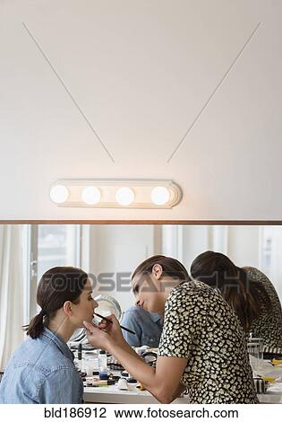 Stock Image - Woman having makeup applied by stylist. Fotosearch