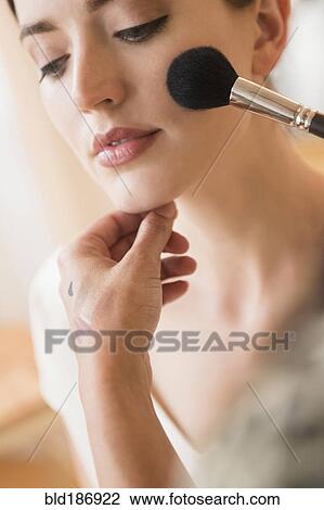 Stock Image - Woman having makeup applied by stylist. Fotosearch