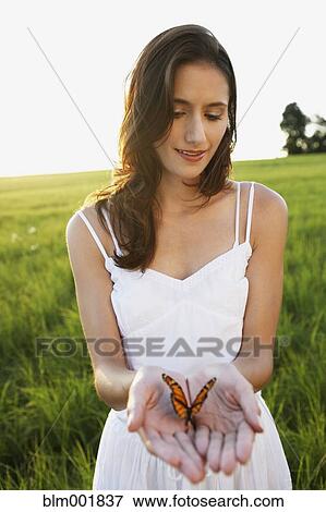 Stock Photo - Woman holding butterfly in hands. Fotosearch