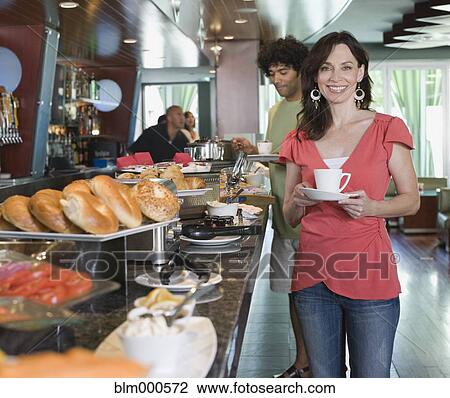 Woman holding coffee cup near breakfast buffet View Large Photo Image Stock Image - Woman holding coffee cup near breakfast buffet. Fotosearch