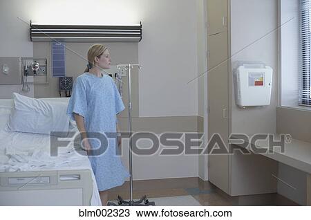 Stock Image - Woman in hospital gown with IV. Fotosearch