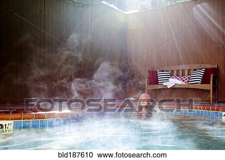Stock Image - Woman relaxing in hot tub. Fotosearch