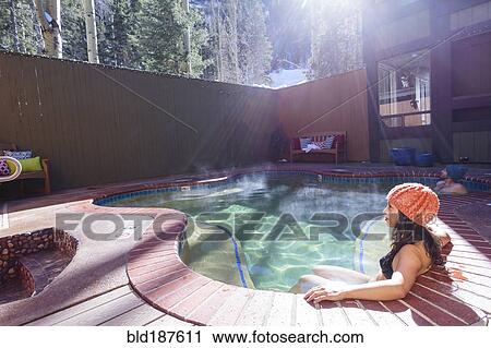 Stock Image - Woman relaxing in hot tub. Fotosearch