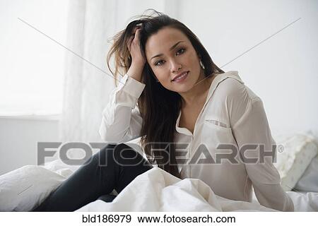 Stock Photo - Woman smiling on bed. Fotosearch