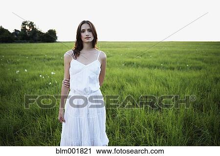 Stock Image - Woman standing in meadow. Fotosearch