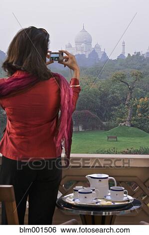 Stock Photograph - Woman taking photograph of the Taj Mahal. Fotosearch