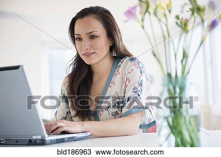 Woman using laptop at desk View Large Photo Image Stock Image - Woman using laptop at desk. Fotosearch