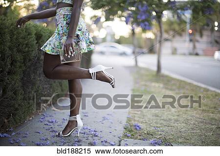 Stock Photography - Woman wearing heels on neighborhood sidewalk. Fotosearch