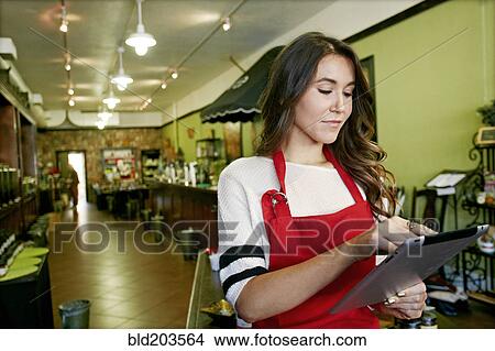 Picture - Woman working in grocery store. Fotosearch