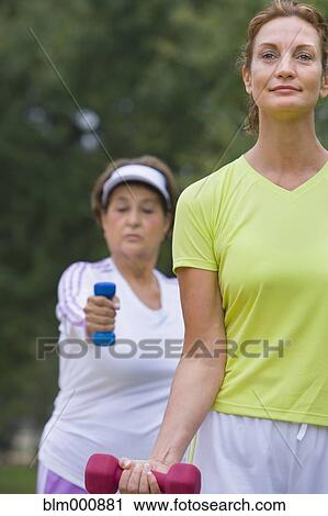 Stock Image - Women lifting hand weights. Fotosearch