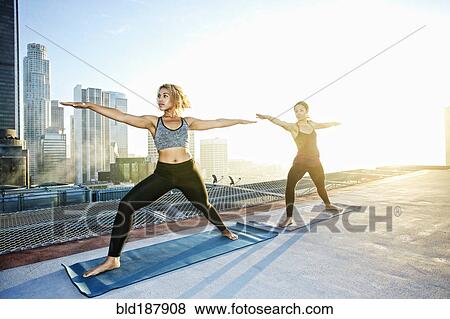Women practicing yoga on urban rooftop View Large Photo Image Stock Photo - Women practicing yoga on urban rooftop. Fotosearch