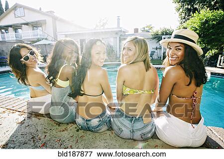 Stock Photo - Women sitting at swimming pool. Fotosearch