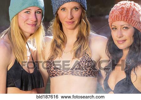 Stock Photograph - Women smiling in bikinis and beanie hats. Fotosearch