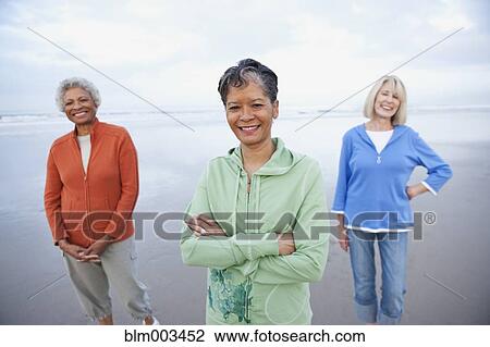 Stock Image - Women walking on beach together. Fotosearch
