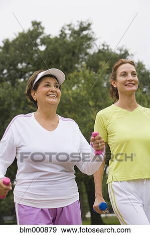 Stock Photo - Women walking with hand weights. Fotosearch