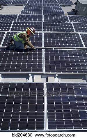 Worker examining solar panels outdoors View Large Photo Image Stock Image - Worker examining solar panels outdoors. Fotosearch