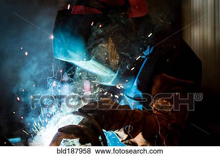 Stock Photo - Worker welding in workshop. Fotosearch