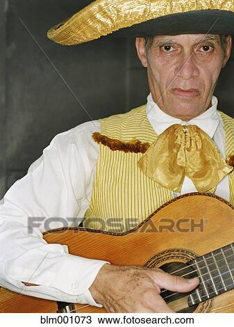 Young man in traditional clothing playing guitar View Large Photo Image Stock Image - Young man in traditional clothing playing guitar. Fotosearch