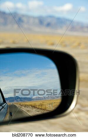 Stock Image - A car driving through the desert landscape. Fotosearch